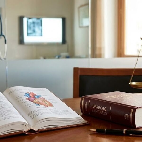 Libro de medicina y código legal sobre un escritorio profesional, representando el concepto de lex artis en el derecho sanitario.